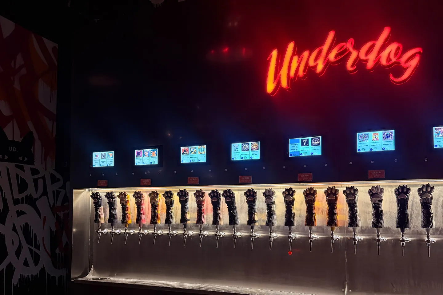 ป้ายไฟ Underdog เหนือกำแพงแท็ป self-pour ในร้าน Underdog พัฒนาการ
